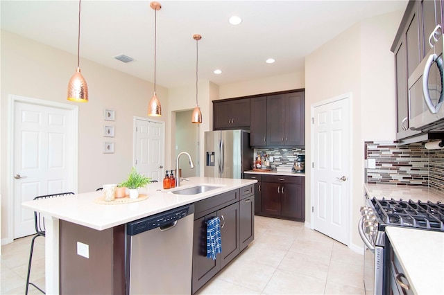 kitchen with dark brown cabinetry, visible vents, appliances with stainless steel finishes, light countertops, and a sink