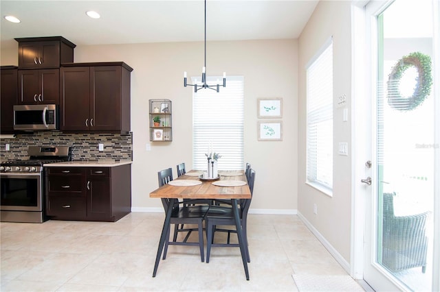 kitchen featuring dark brown cabinetry, tasteful backsplash, light tile patterned floors, stainless steel appliances, and light countertops