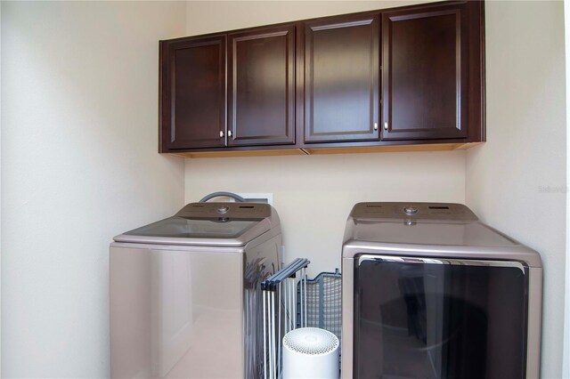 laundry room featuring washer and clothes dryer and cabinet space