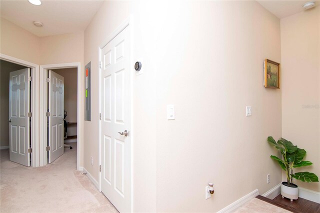 hallway with light carpet and baseboards