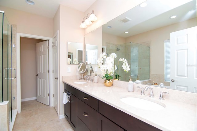 full bath featuring tile patterned flooring, a sink, a shower stall, and double vanity