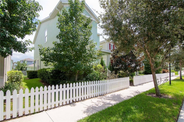 view of front of property with a front lawn, a fenced front yard, and stucco siding