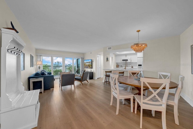 dining room with light wood-style floors, baseboards, and visible vents