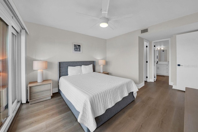 bedroom featuring baseboards, visible vents, ceiling fan, and wood finished floors