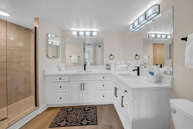 full bathroom featuring wood finished floors, a stall shower, and a sink