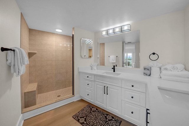 bathroom with a walk in shower, wood finished floors, and vanity