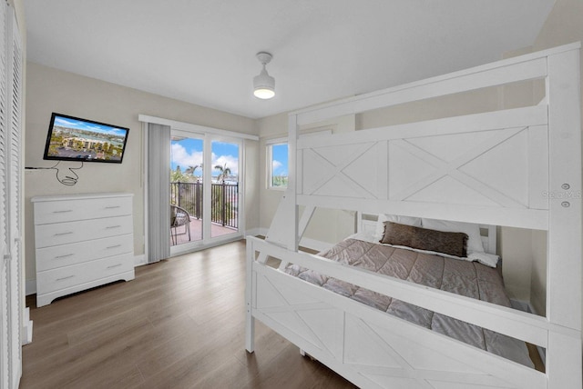 bedroom featuring access to exterior and wood finished floors