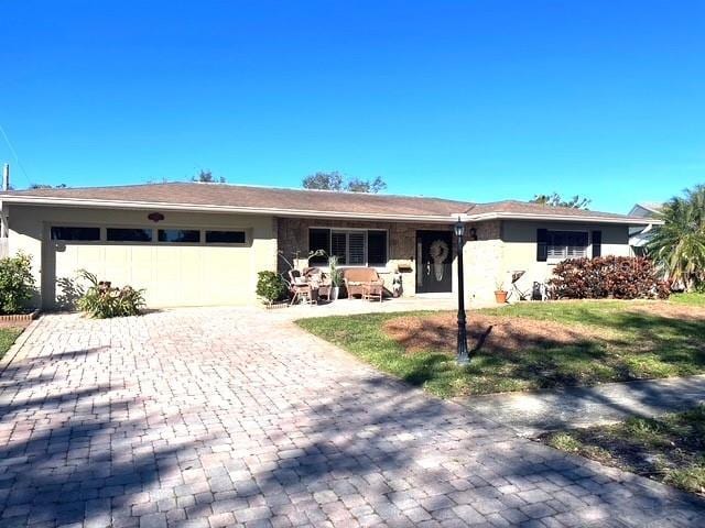 ranch-style house with a garage and a front lawn