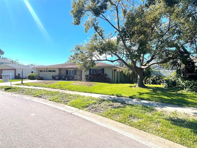 ranch-style house featuring a garage and a front lawn