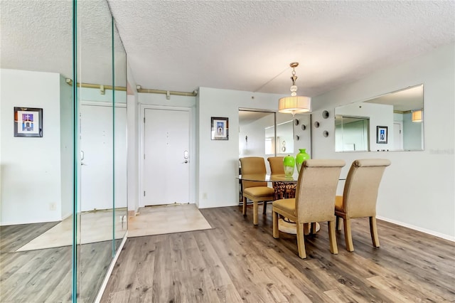 dining area with a textured ceiling and hardwood / wood-style floors