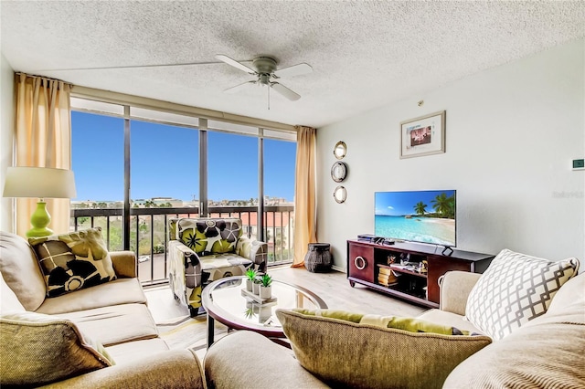 living room featuring ceiling fan, expansive windows, and a textured ceiling