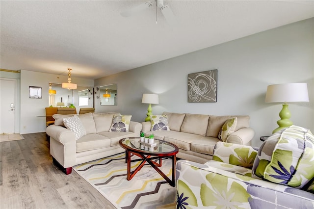 living room featuring ceiling fan, a textured ceiling, and hardwood / wood-style flooring