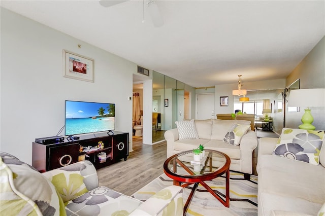 living room featuring light hardwood / wood-style floors and ceiling fan