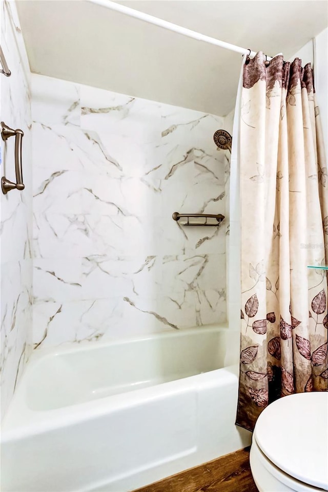 bathroom with toilet, shower / tub combo, and wood-type flooring