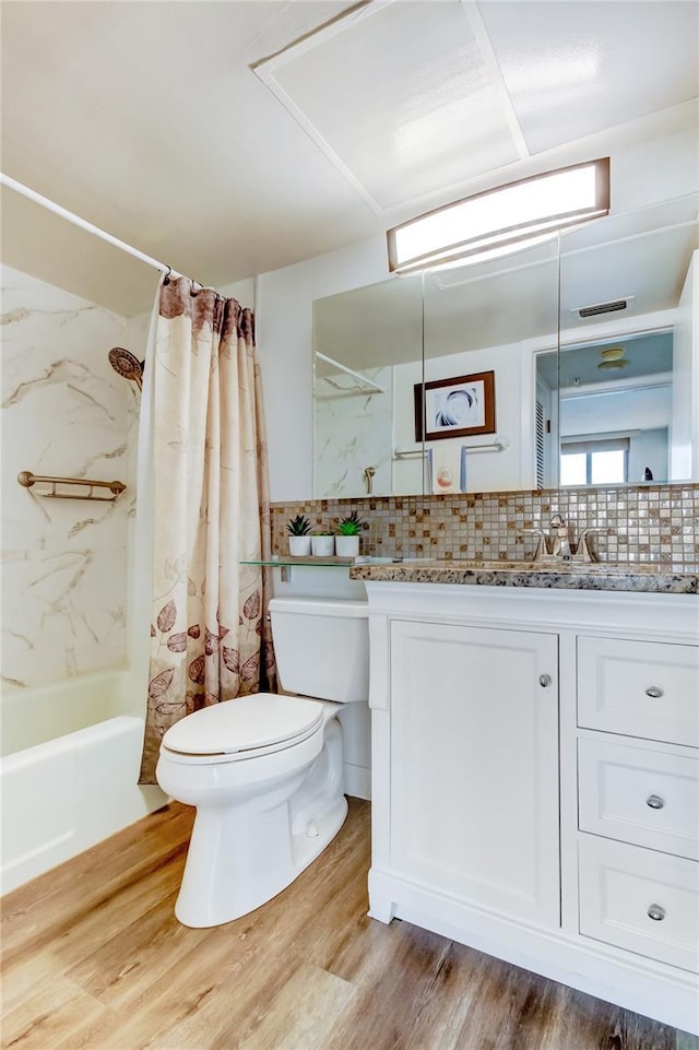 full bathroom featuring toilet, vanity, backsplash, hardwood / wood-style floors, and shower / bath combination with curtain