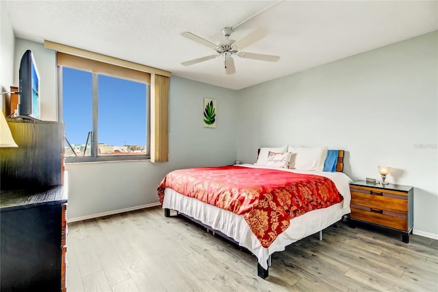 bedroom featuring ceiling fan, hardwood / wood-style floors, and a textured ceiling