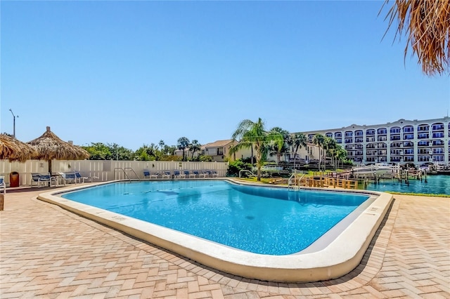 view of pool with a patio area and a water view