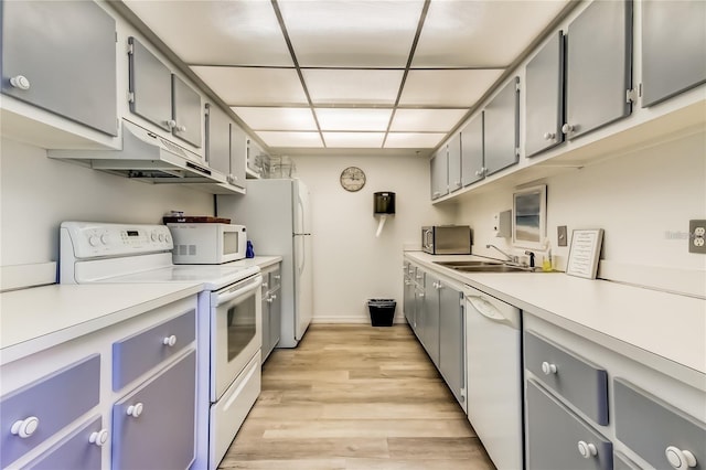 kitchen with sink, white appliances, gray cabinets, and light hardwood / wood-style flooring