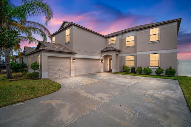 front facade featuring a garage and a yard