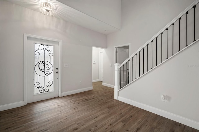 foyer with dark hardwood / wood-style floors and a chandelier