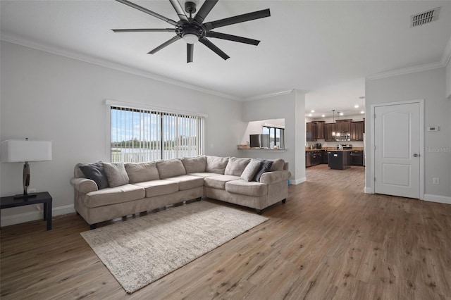 living room with ceiling fan, crown molding, and hardwood / wood-style flooring