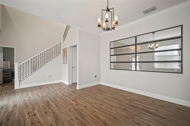 empty room featuring dark hardwood / wood-style flooring, ornamental molding, and a chandelier