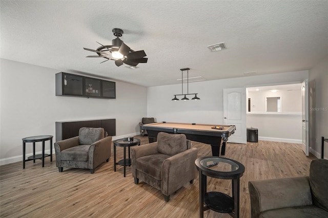 living room featuring light hardwood / wood-style floors, a textured ceiling, billiards, and ceiling fan