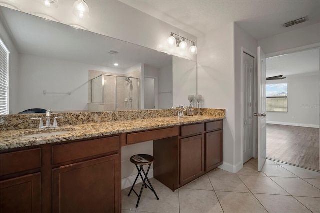 bathroom with an enclosed shower, vanity, and tile patterned flooring