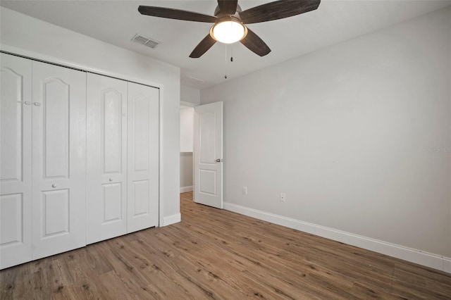 unfurnished bedroom with ceiling fan, a closet, and light wood-type flooring