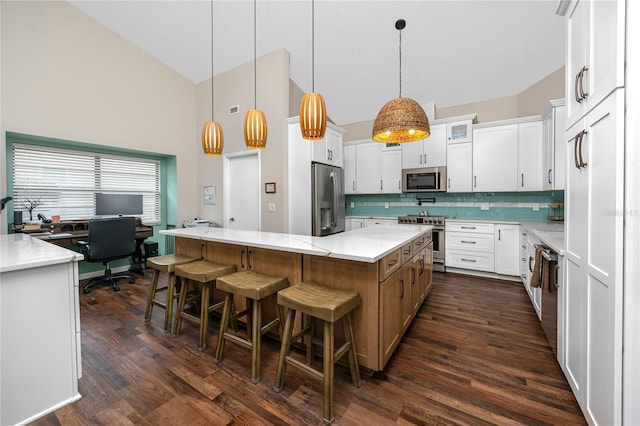 kitchen featuring white cabinetry, a large island, decorative light fixtures, and appliances with stainless steel finishes