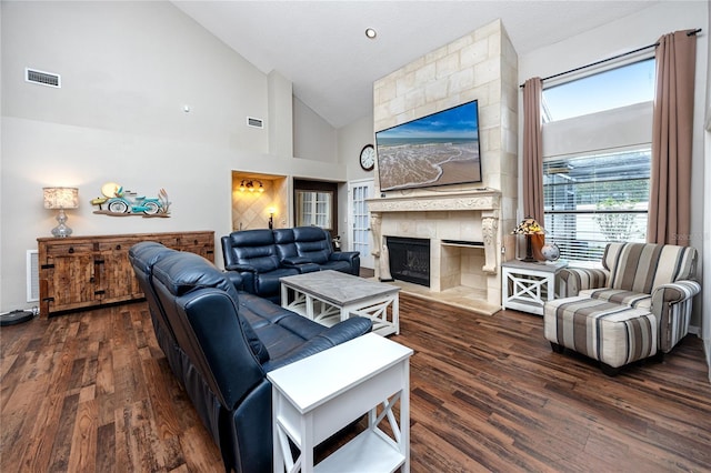 living room with dark hardwood / wood-style flooring, a fireplace, and high vaulted ceiling