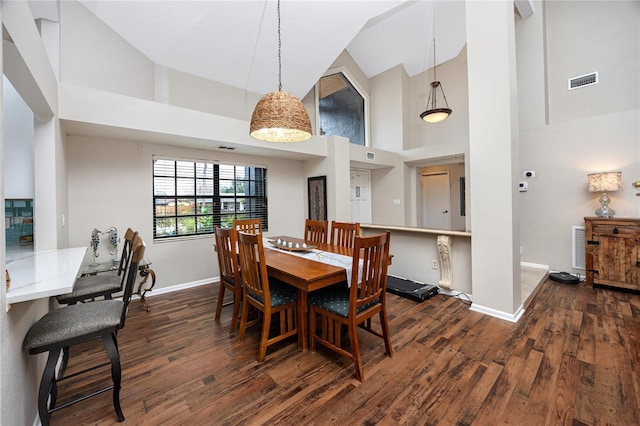 dining space featuring high vaulted ceiling and dark hardwood / wood-style floors