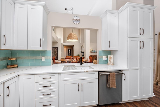 kitchen with pendant lighting, sink, backsplash, white cabinets, and stainless steel dishwasher