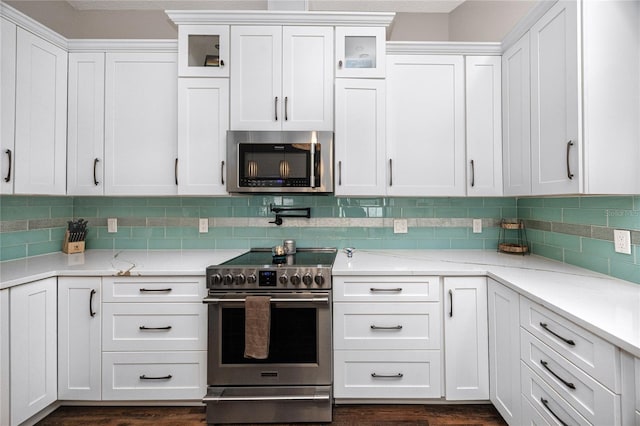 kitchen with light stone counters, white cabinets, and appliances with stainless steel finishes