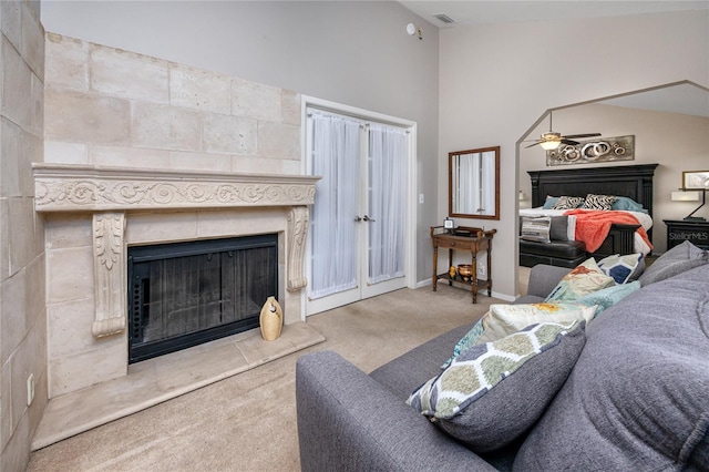 living room featuring light carpet, a fireplace, lofted ceiling, and ceiling fan