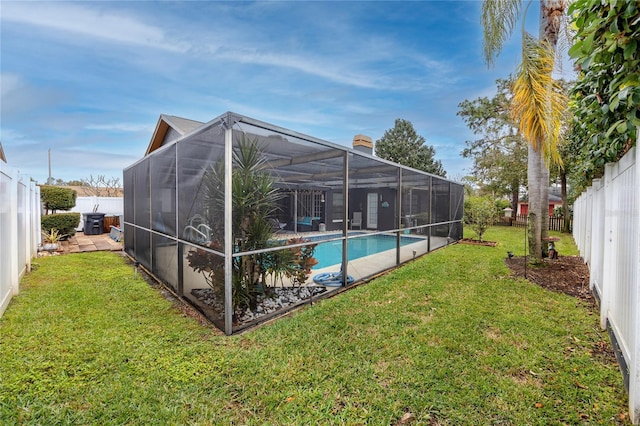 view of pool with a lanai and a lawn