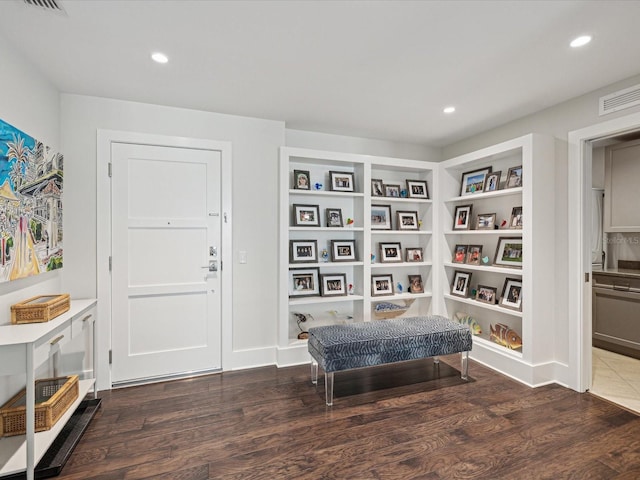 living area with dark wood-type flooring and built in features