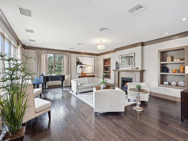 living room with crown molding, dark hardwood / wood-style floors, and built in features