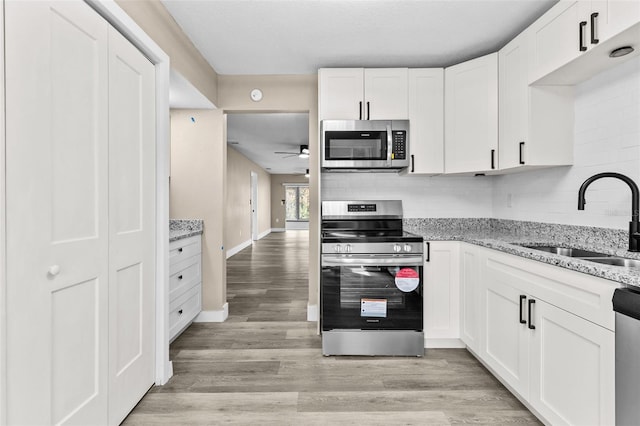 kitchen with sink, white cabinets, and appliances with stainless steel finishes