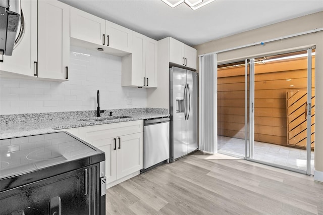 kitchen featuring light stone countertops, sink, white cabinets, and appliances with stainless steel finishes