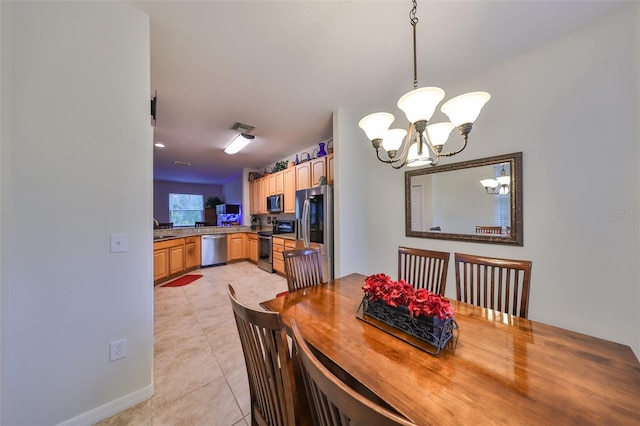 dining area featuring light tile patterned floors, a chandelier, and sink