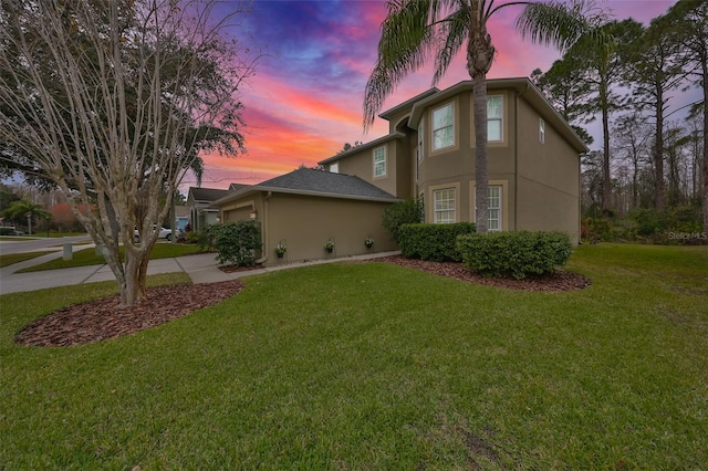 12127 Luftburrow Ln, Hudson, FL 34669 - view of front of house featuring stucco siding, an attached garage, concrete driveway, and a yard