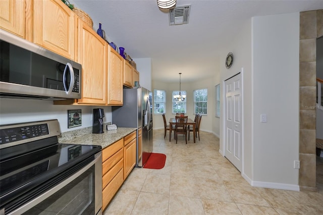 12127 Luftburrow Ln, Hudson, FL 34669 - kitchen with light tile patterned floors, visible vents, light stone countertops, stainless steel appliances, and light brown cabinetry