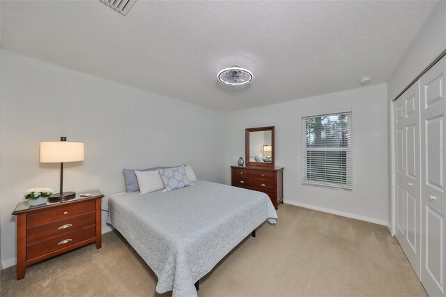 12127 Luftburrow Ln, Hudson, FL 34669 - bedroom with baseboards, a textured ceiling, visible vents, light carpet, and a closet