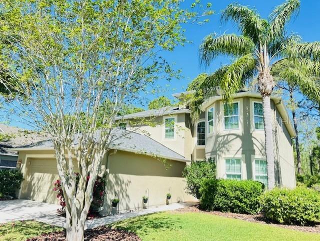 12127 Luftburrow Ln, Hudson, FL 34669 - exterior space featuring stucco siding, an attached garage, and concrete driveway