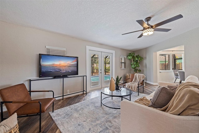 living room with a textured ceiling, baseboard heating, french doors, ceiling fan, and dark hardwood / wood-style floors