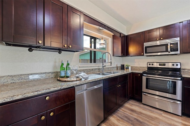 kitchen featuring sink, stainless steel appliances, light hardwood / wood-style floors, and light stone countertops