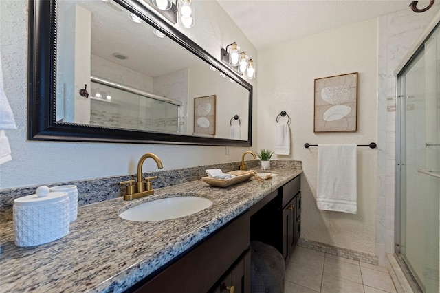 bathroom featuring a shower with shower door, tile patterned floors, and vanity