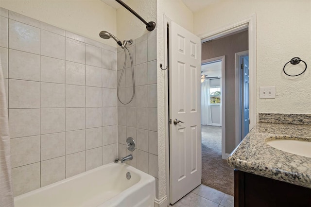 bathroom featuring tiled shower / bath, tile patterned flooring, and vanity