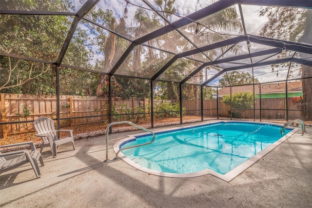 view of swimming pool with glass enclosure and a patio